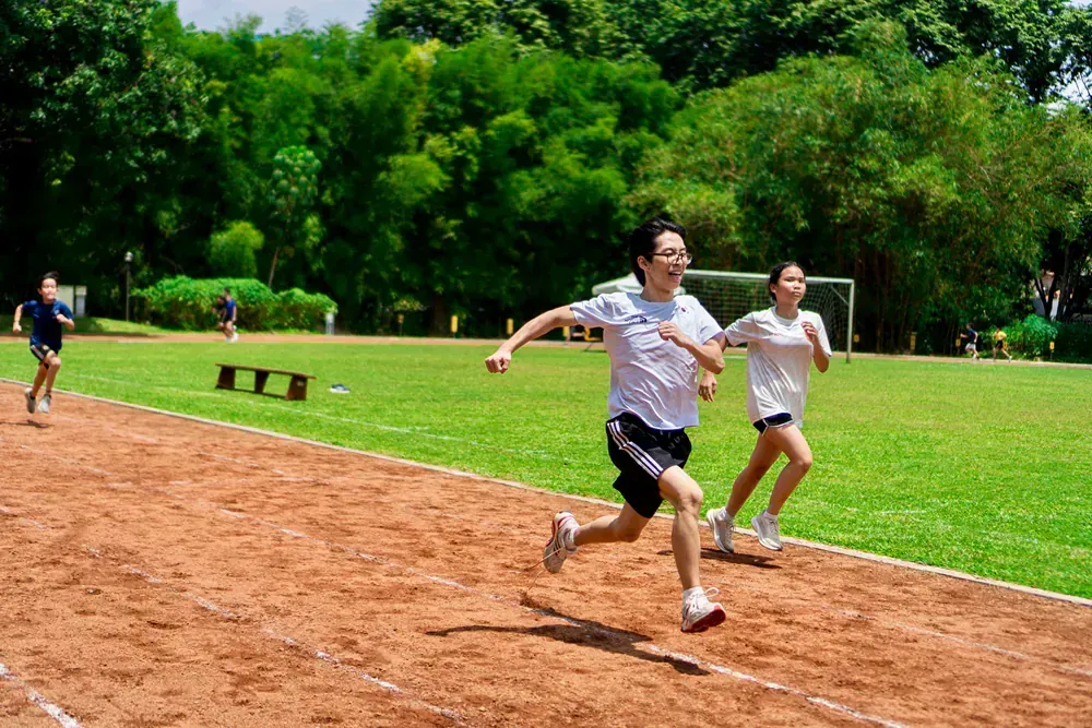 A group of children are running on a dirt track.
