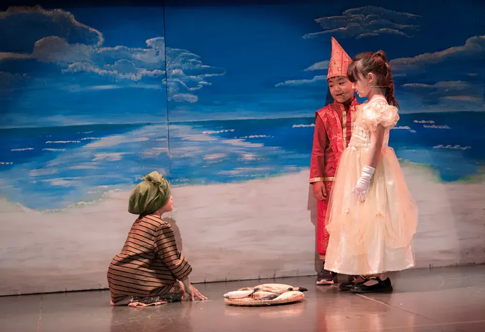 A boy and a girl are standing next to each other on a stage.