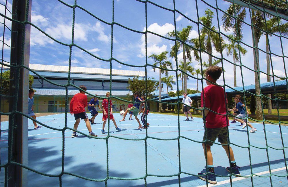A group of children are playing volleyball on a court