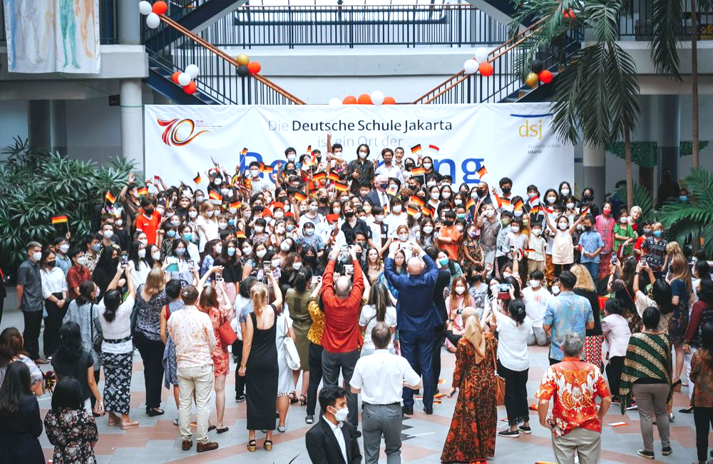 A large group of people are standing in front of a stage.