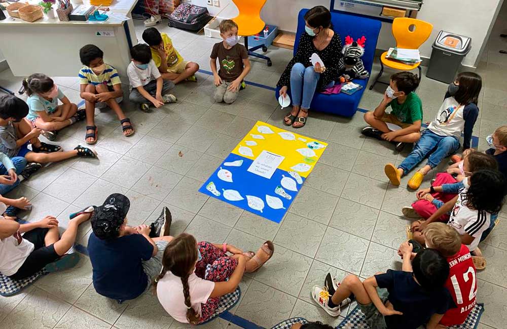 A group of children are sitting in a circle on the floor.