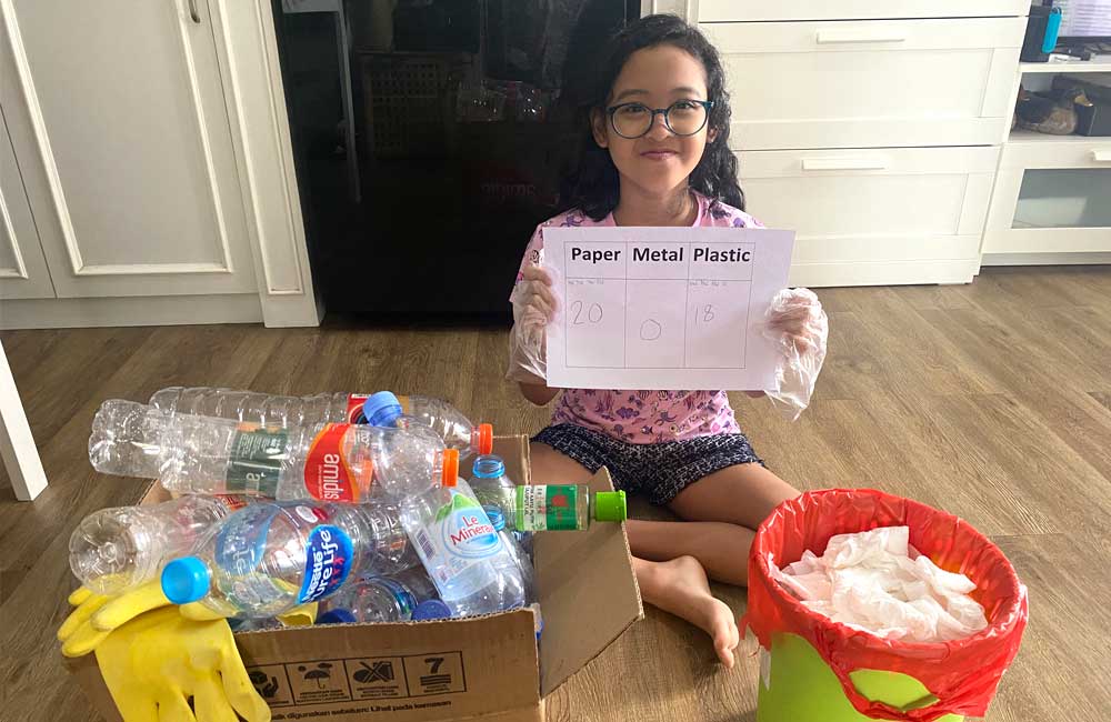 A young girl is sitting on the floor holding a piece of paper.
