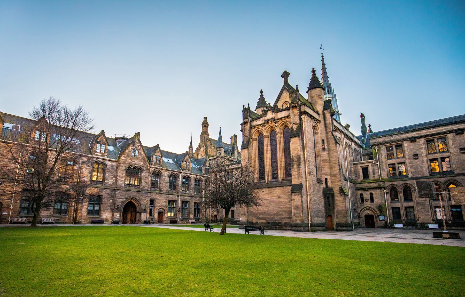 There is a large building with a tower in the middle of the courtyard.