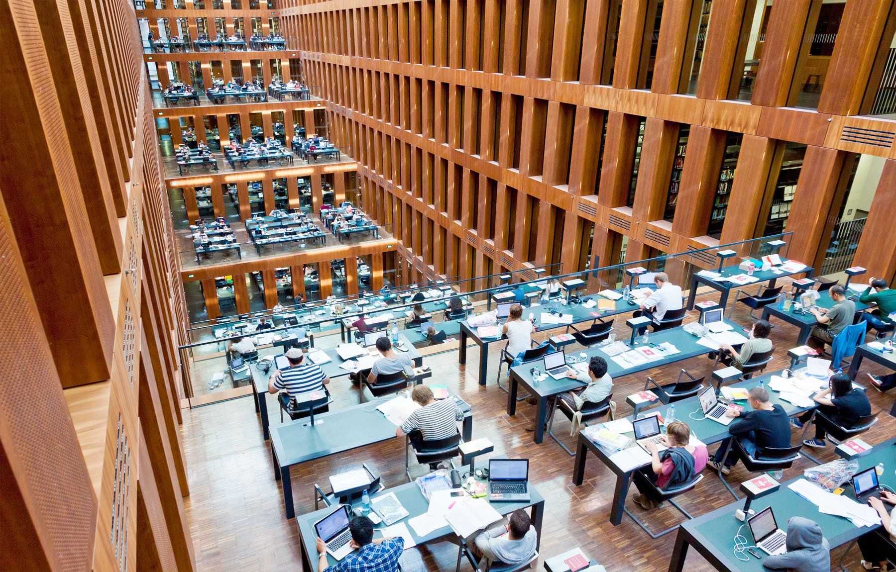 A group of people are sitting at tables in a library.
