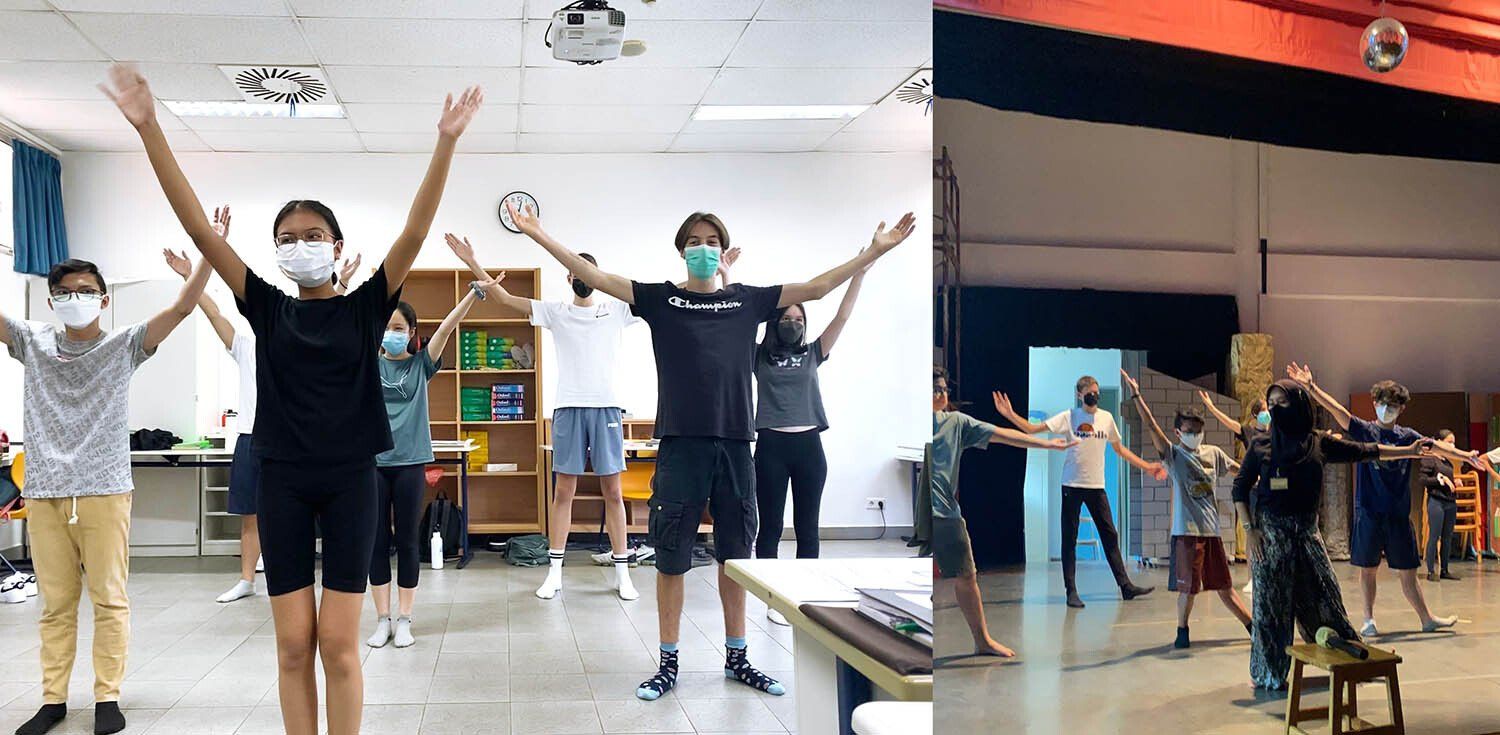 A group of people wearing masks are standing in a room with their arms outstretched.