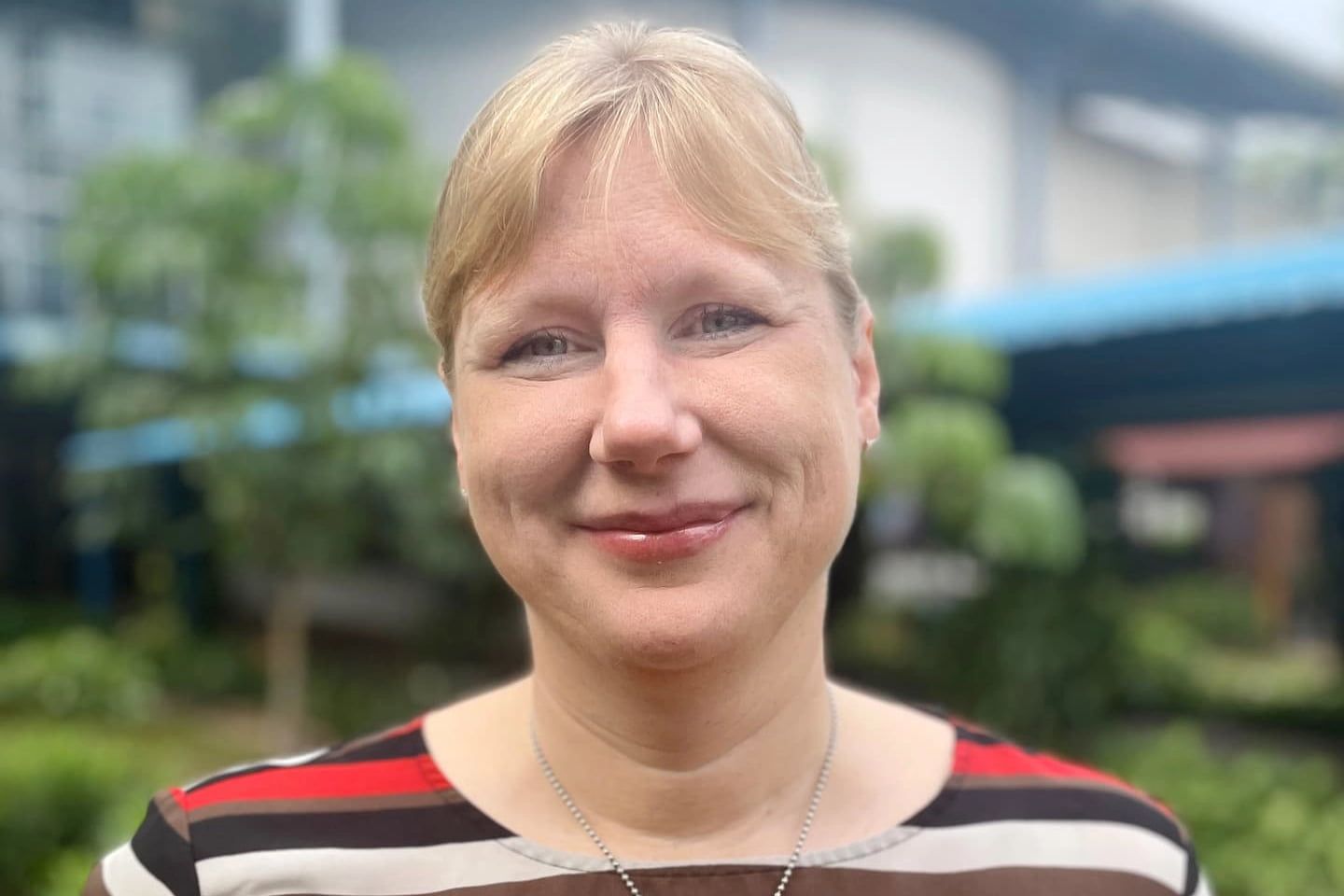 A woman in a striped shirt is smiling for the camera.