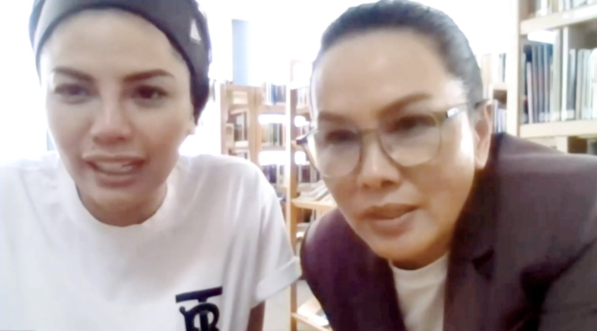 Two women are sitting next to each other on a video call.