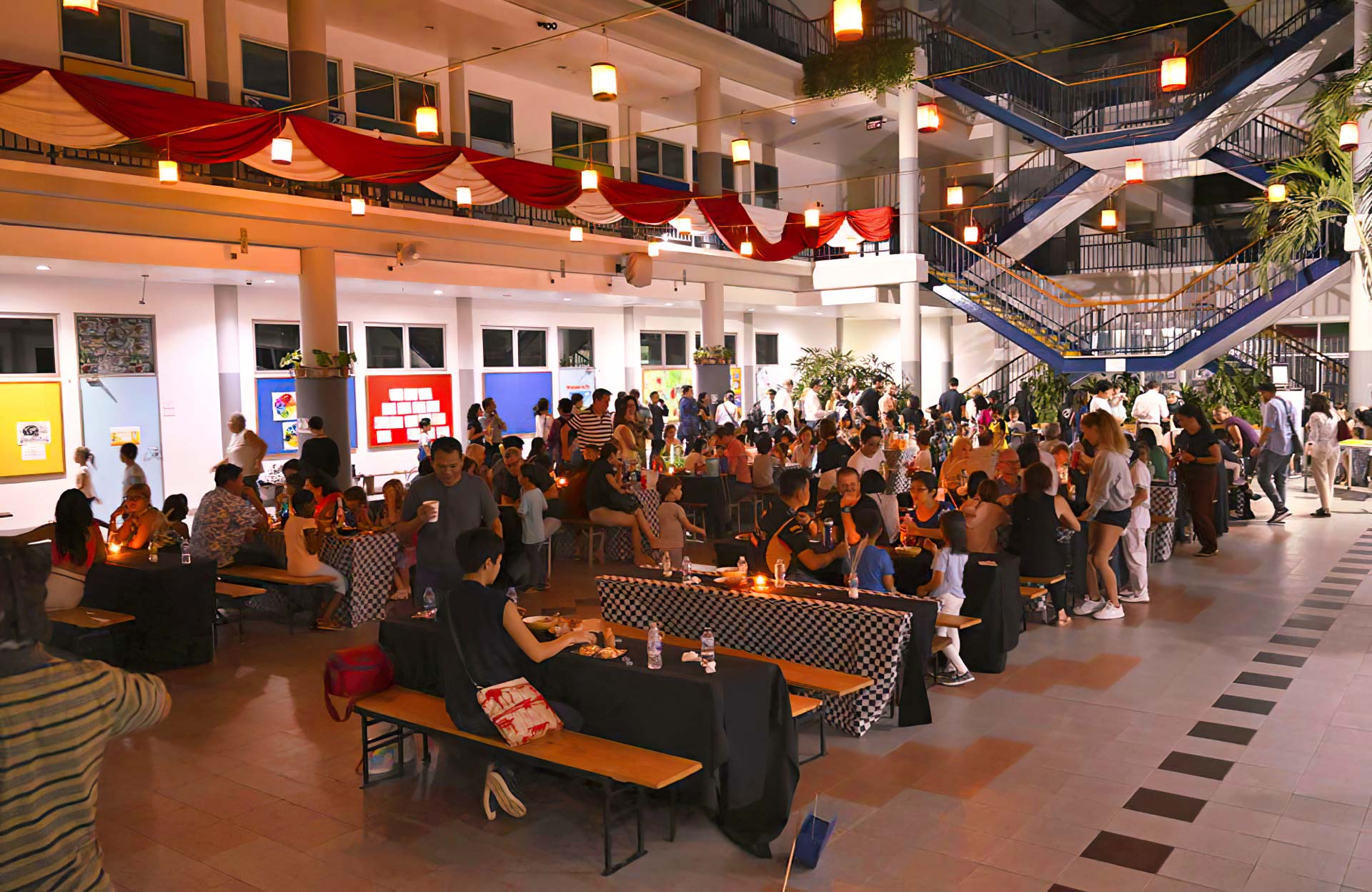 A large group of people are sitting at tables in a large room.