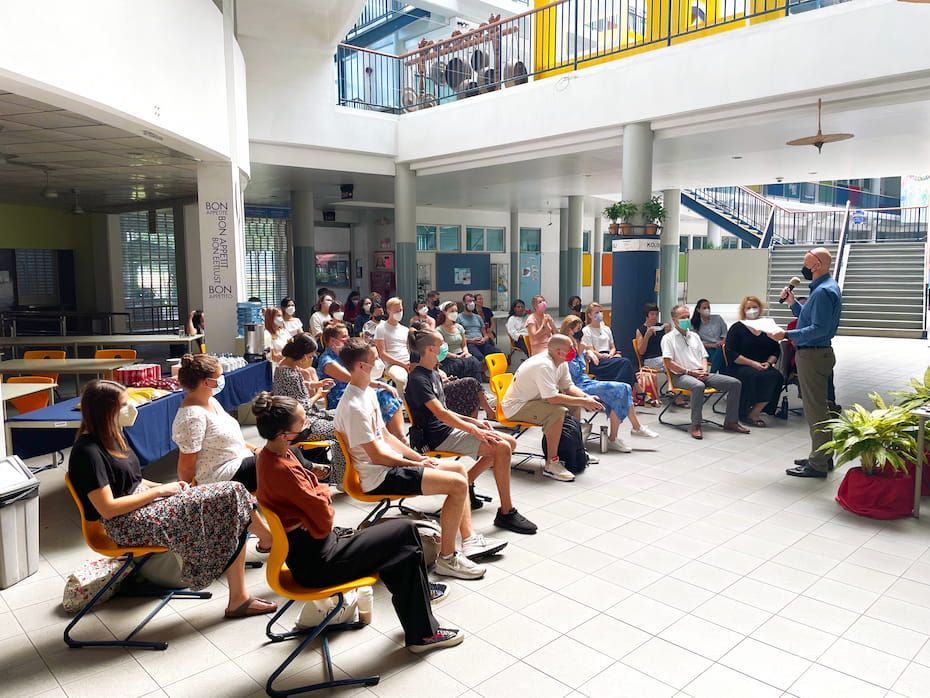 A man is giving a presentation to a group of people sitting in chairs.