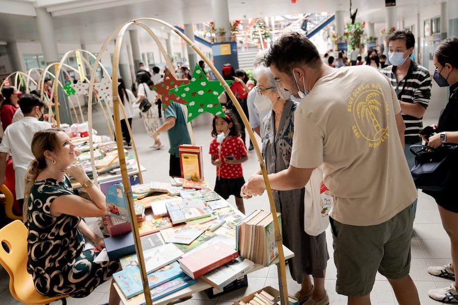 A group of people are standing around a table looking at books.