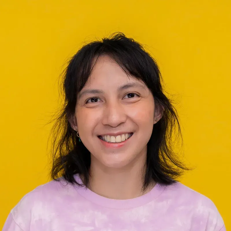A woman wearing a blue and white shirt smiles for the camera