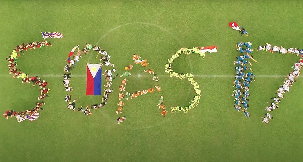 A group of people are standing on a soccer field spelling the word sops17.