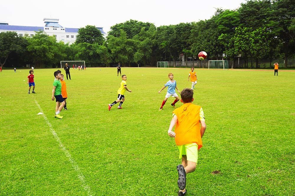A group of children are playing soccer on a field.