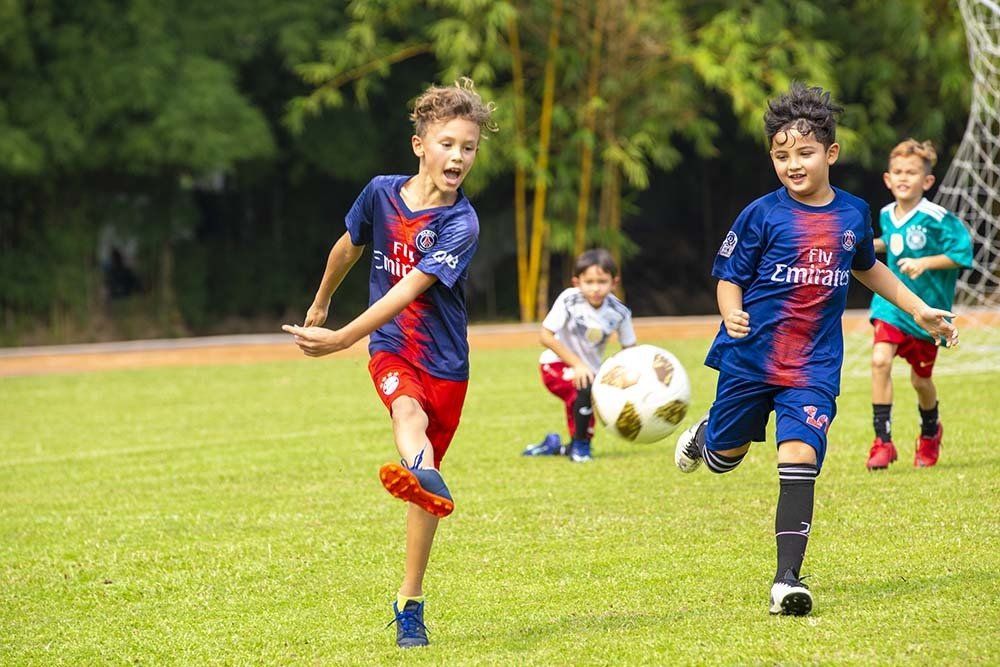A group of young boys are playing soccer on a field.