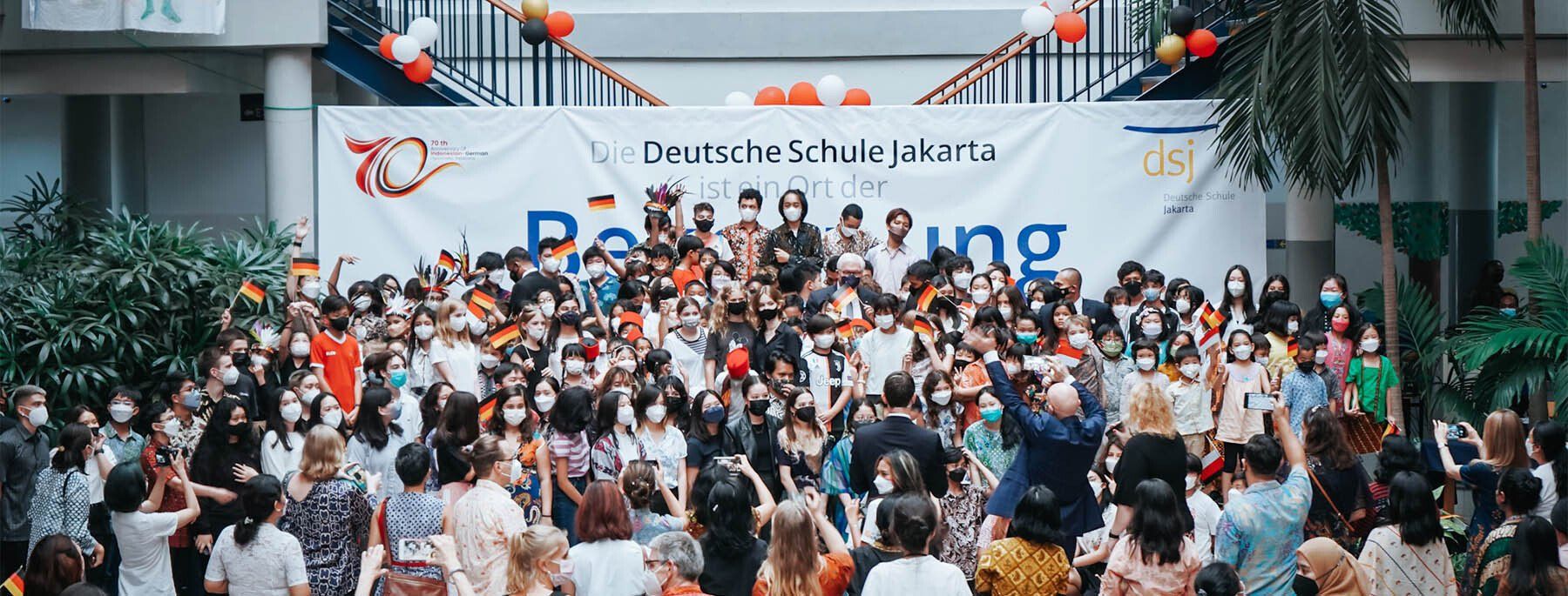 A large group of people are standing in front of a stage.