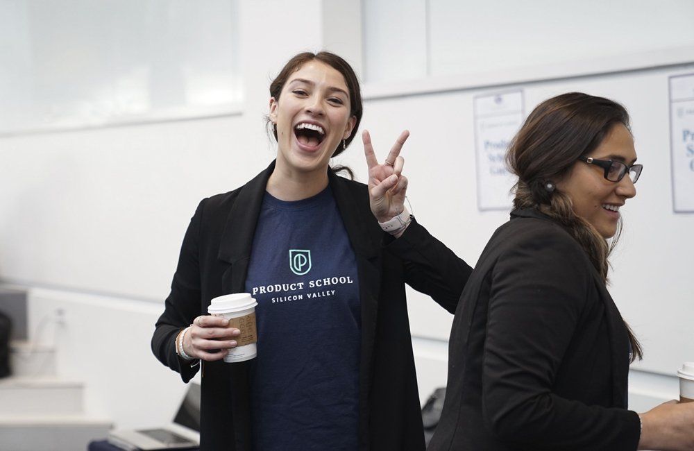 Two women are standing next to each other and one is giving a peace sign.