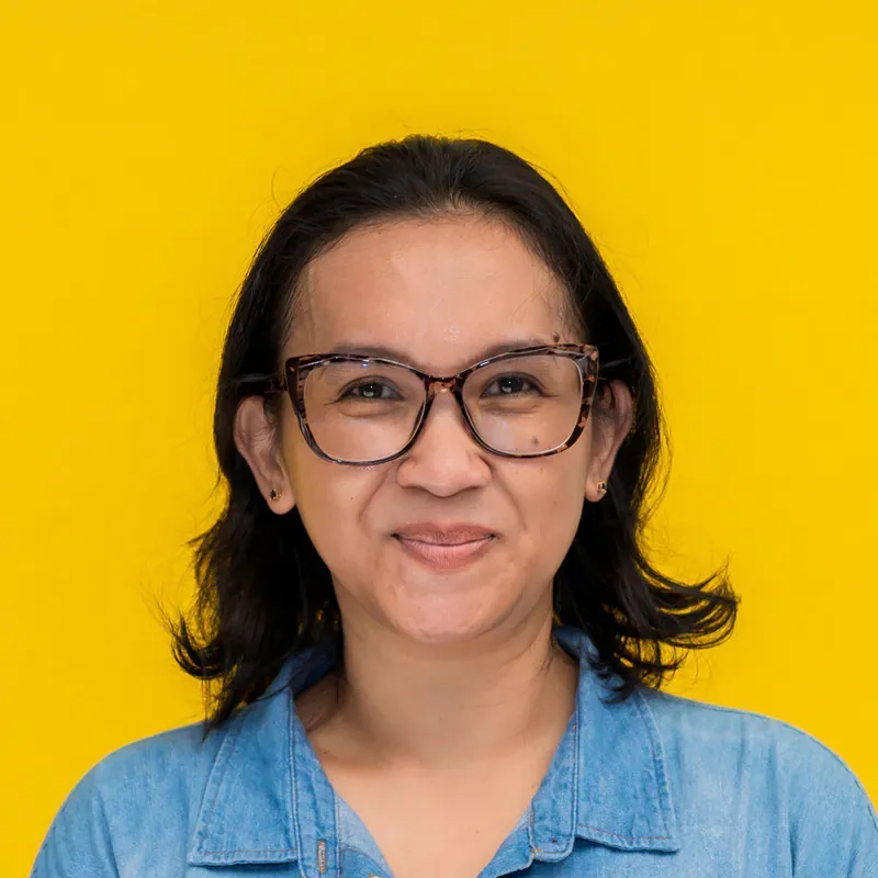 A woman wearing glasses is smiling for the camera.