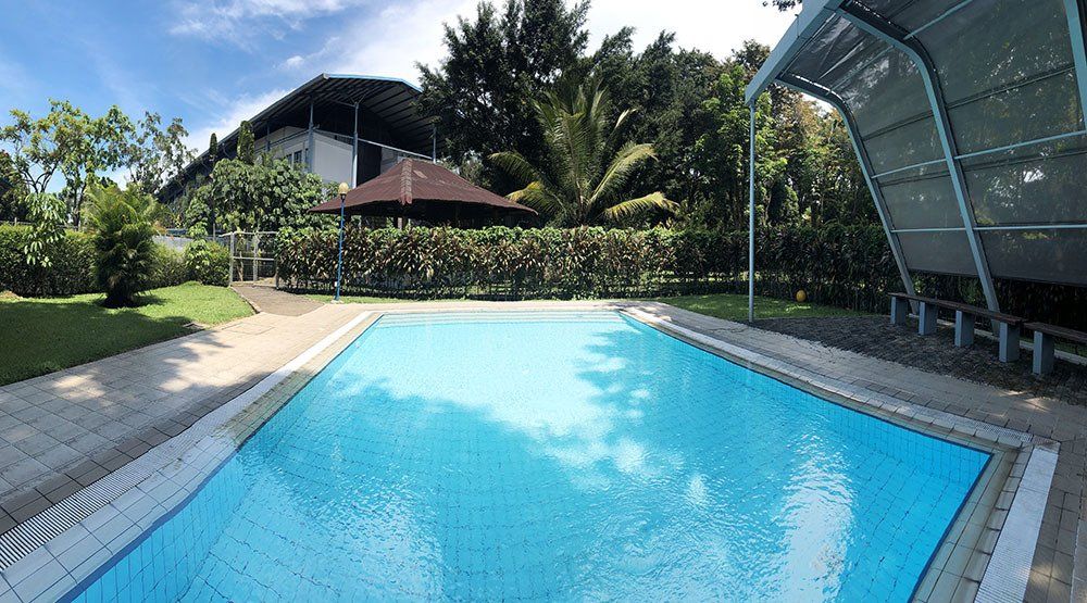 A large swimming pool with a gazebo in the background