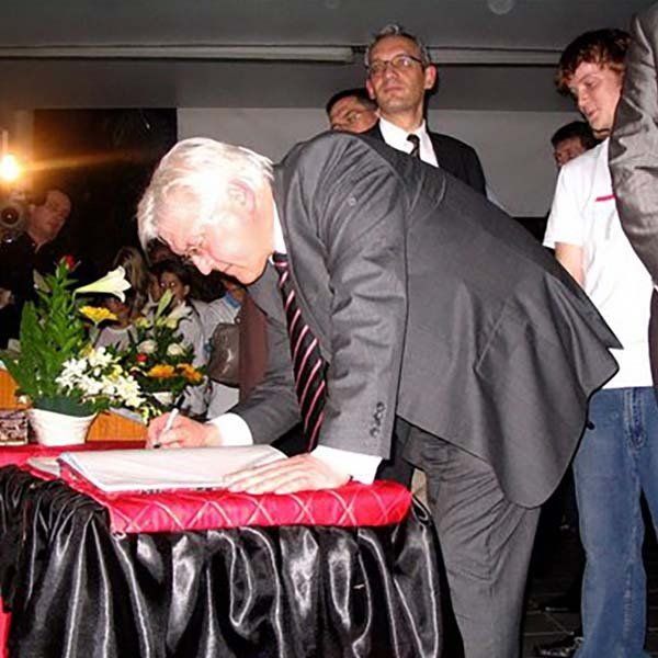 A man in a suit and tie is signing a document