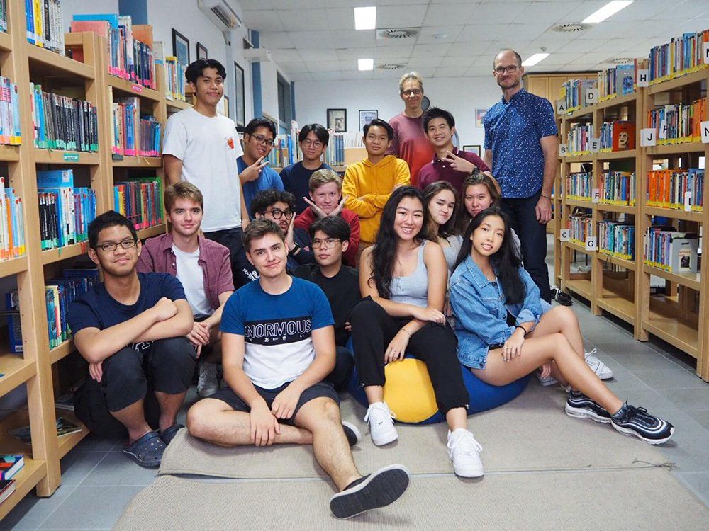 A group of people are posing for a picture in a library.