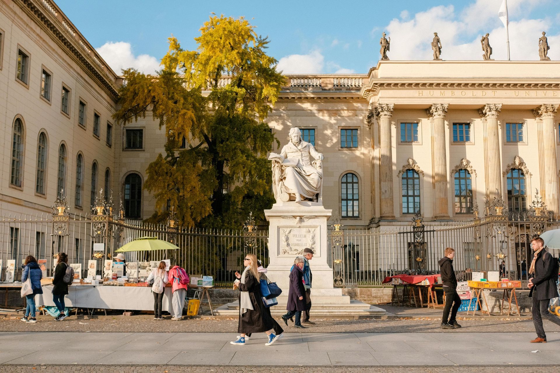Humboldt University building with statue and street market in front