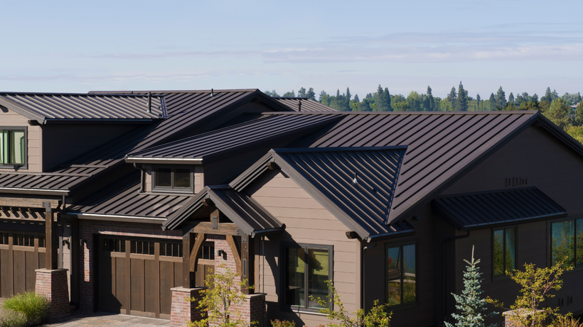 A modern home with a dark brown standing-seam metal roof and earth-toned siding, situated in a suburban setting.