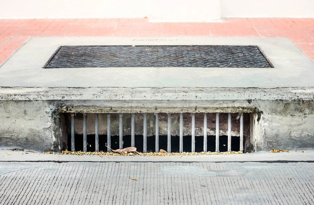 A Drain on the Side of a Road With Bars on It — Houley's Hot Water & Plumbing Wollongong in Russell Vale, NSW 
