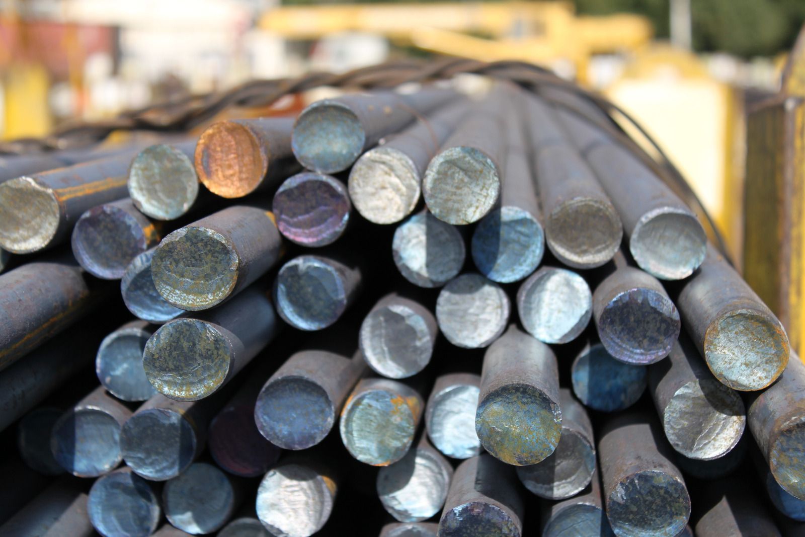 Bundle of round steel bars with varying colors on their ends.