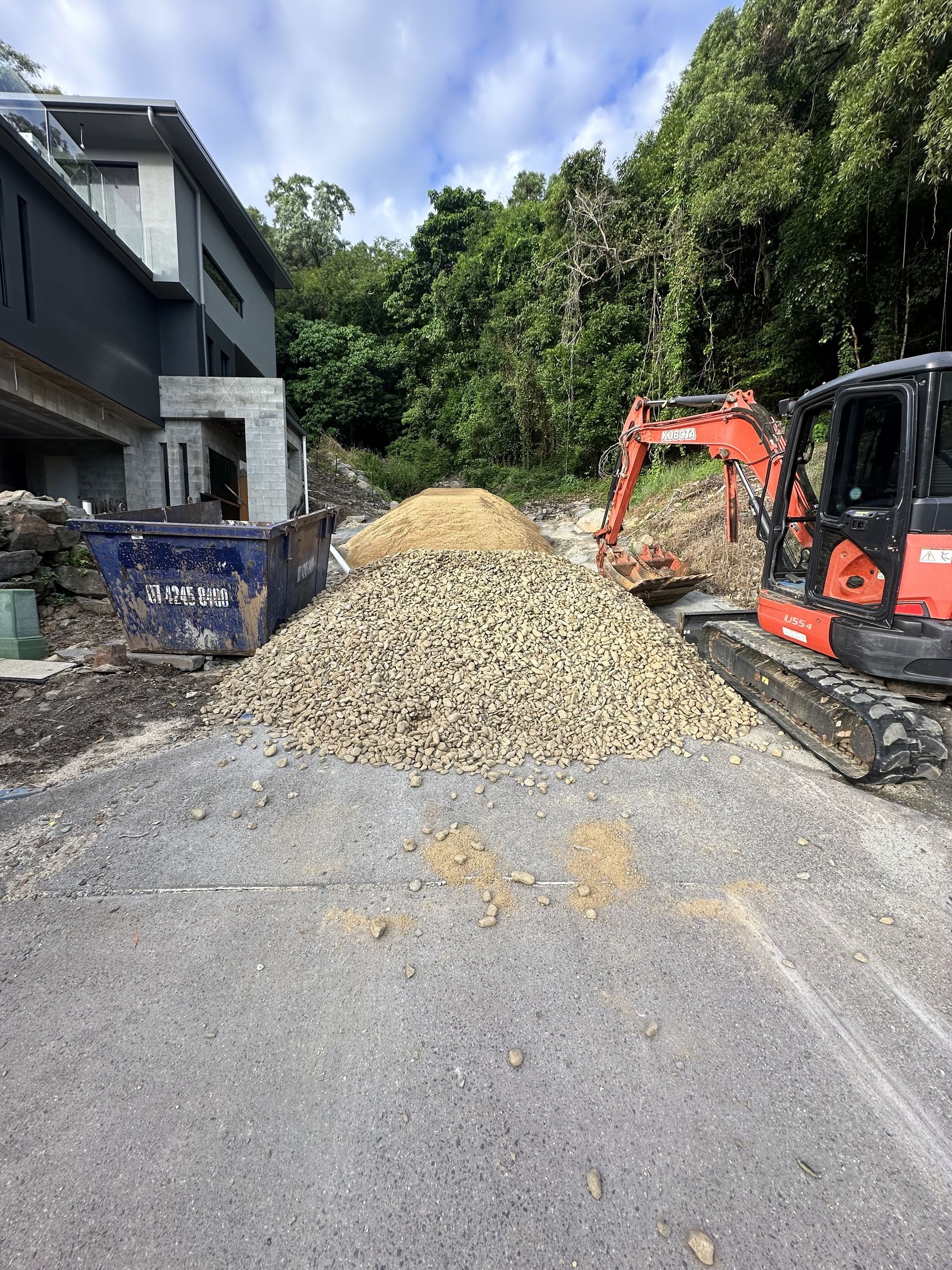 Red Excavator Digging Earth at a Construction Site — Cairns Earthmoving Solutions In Redlynch, QLD