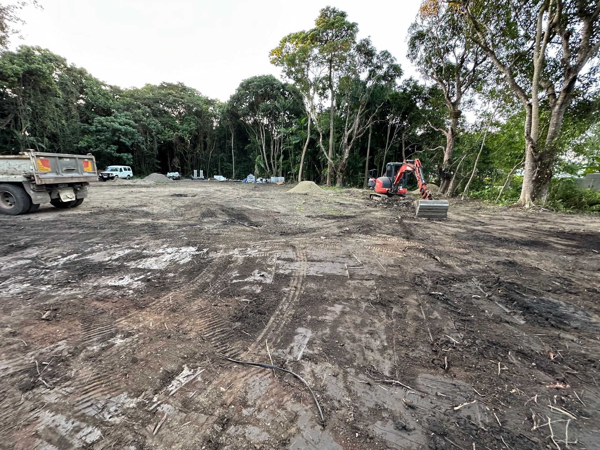 red bobcat doing excavating — Cairns Earthmoving Solutions In Gordonvale, QLD