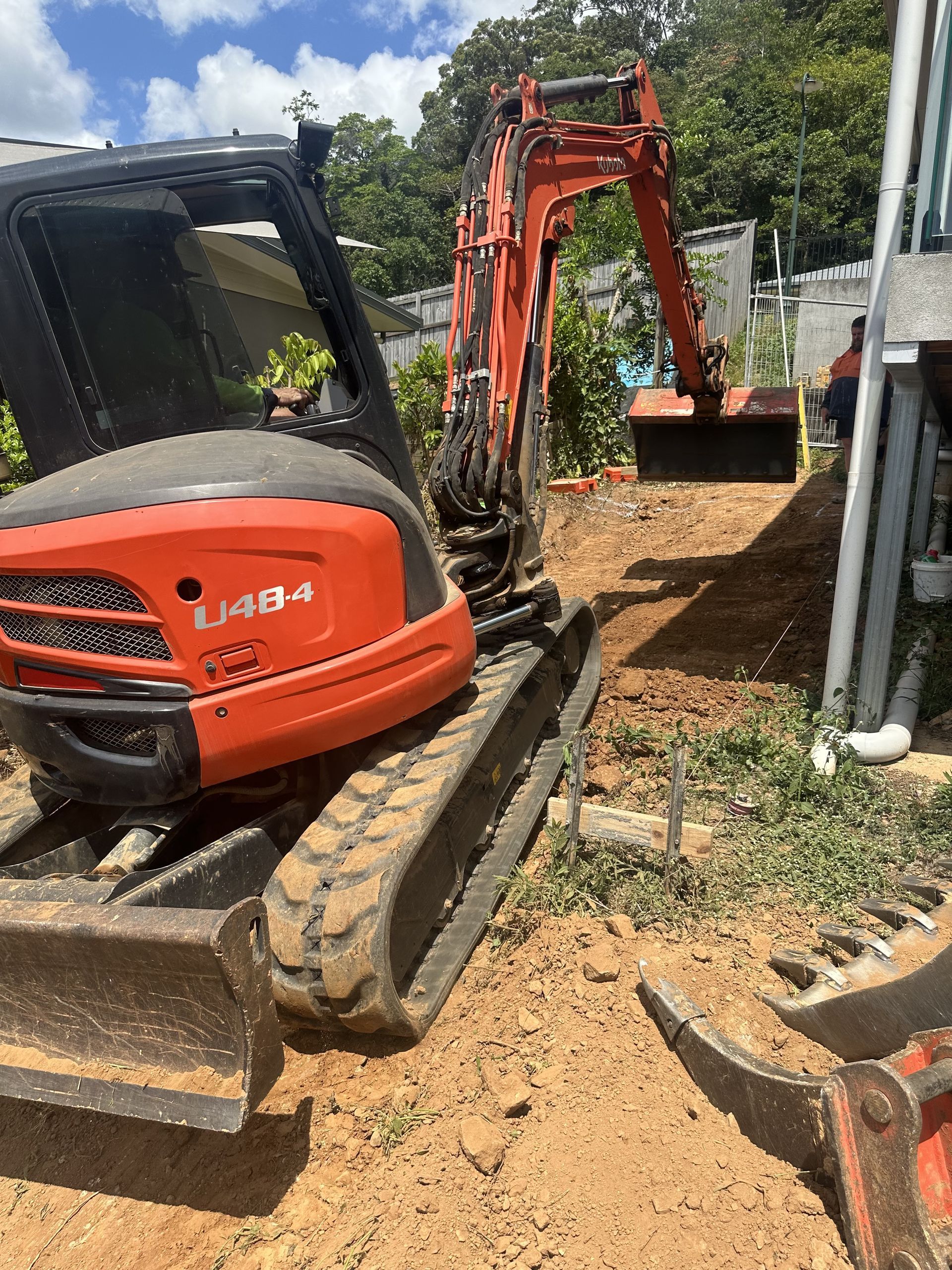 An Excavator Digging Dirt on a Construction Site Under the Sky — Cairns Earthmoving Solutions In Gordonvale, QLD