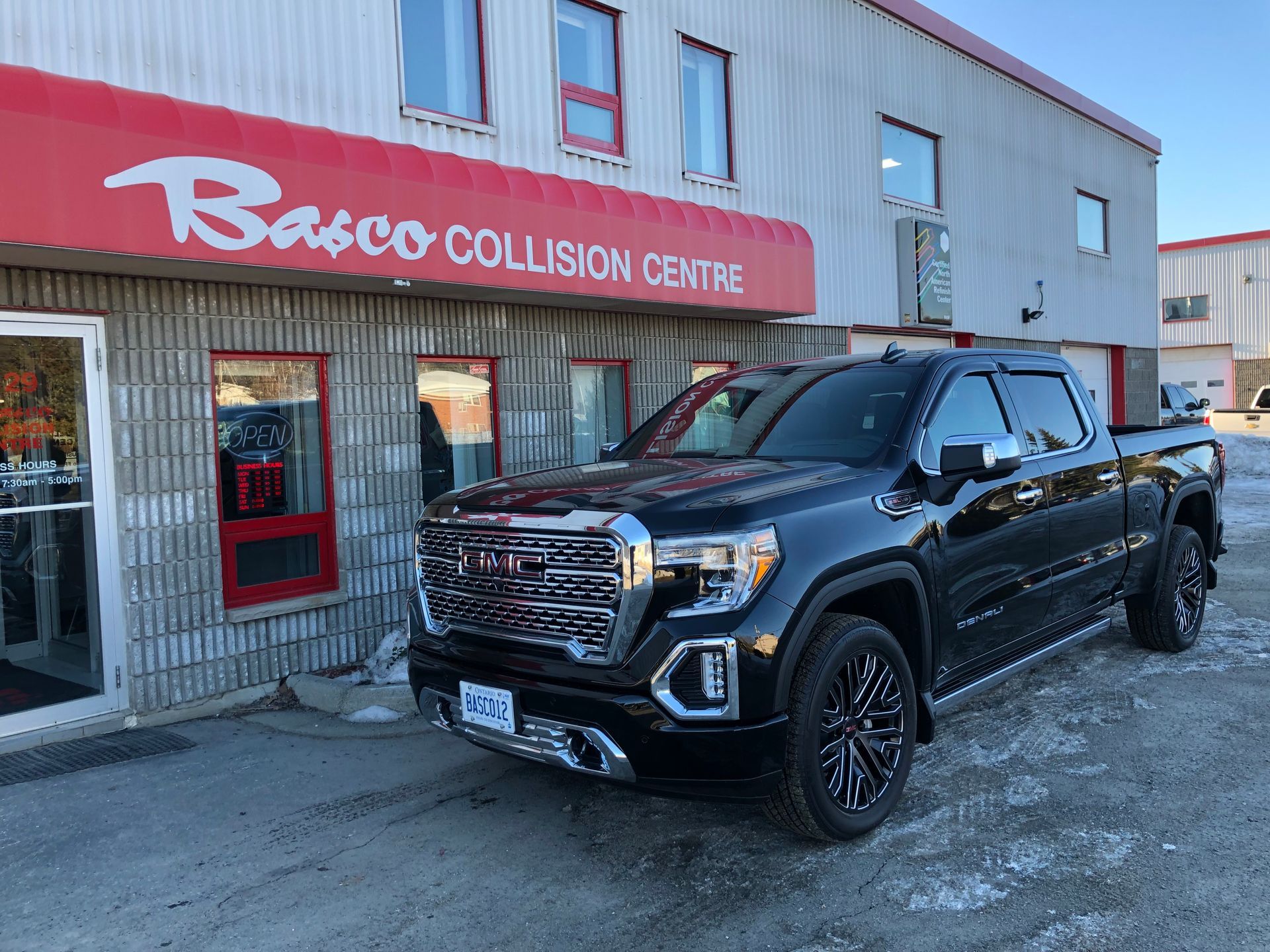 A black pickup truck is parked in front of a building.