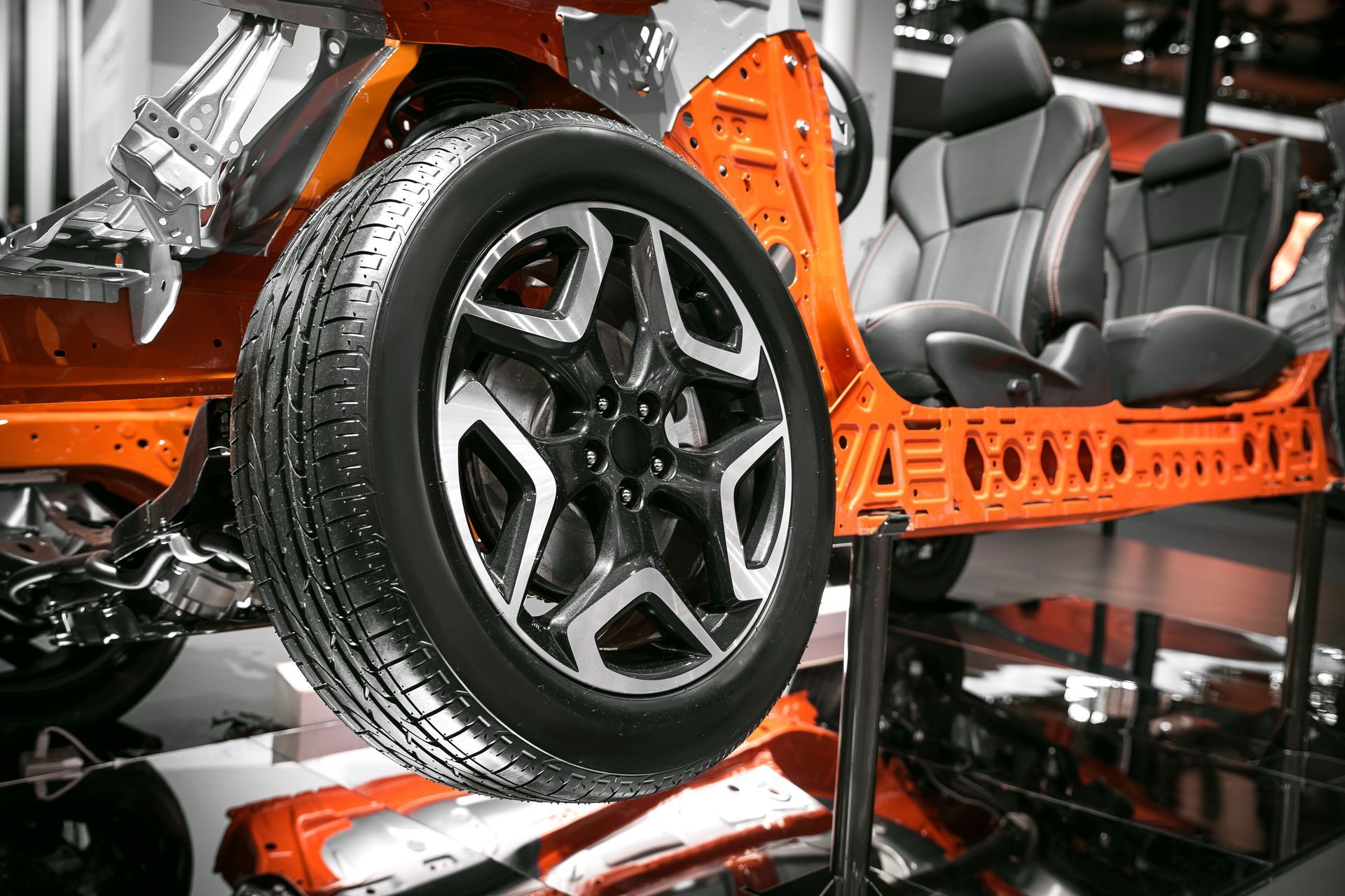 A car is sitting on a lift with a tire on it.