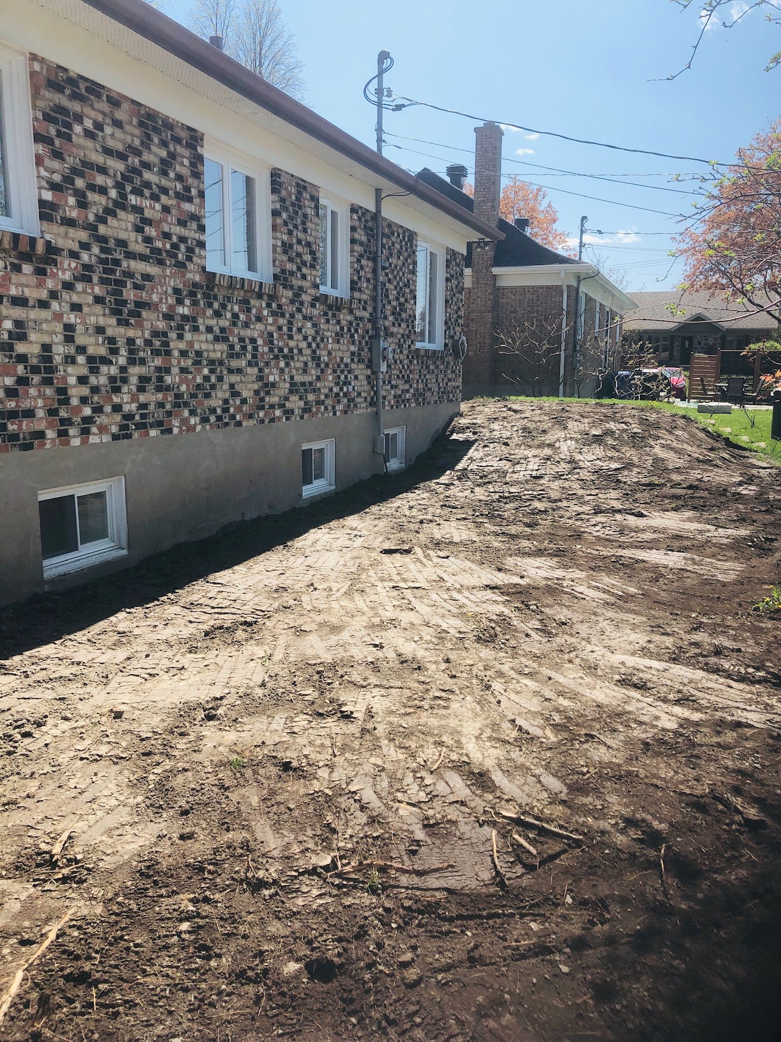 Une maison en brique avec une allée en terre devant elle.