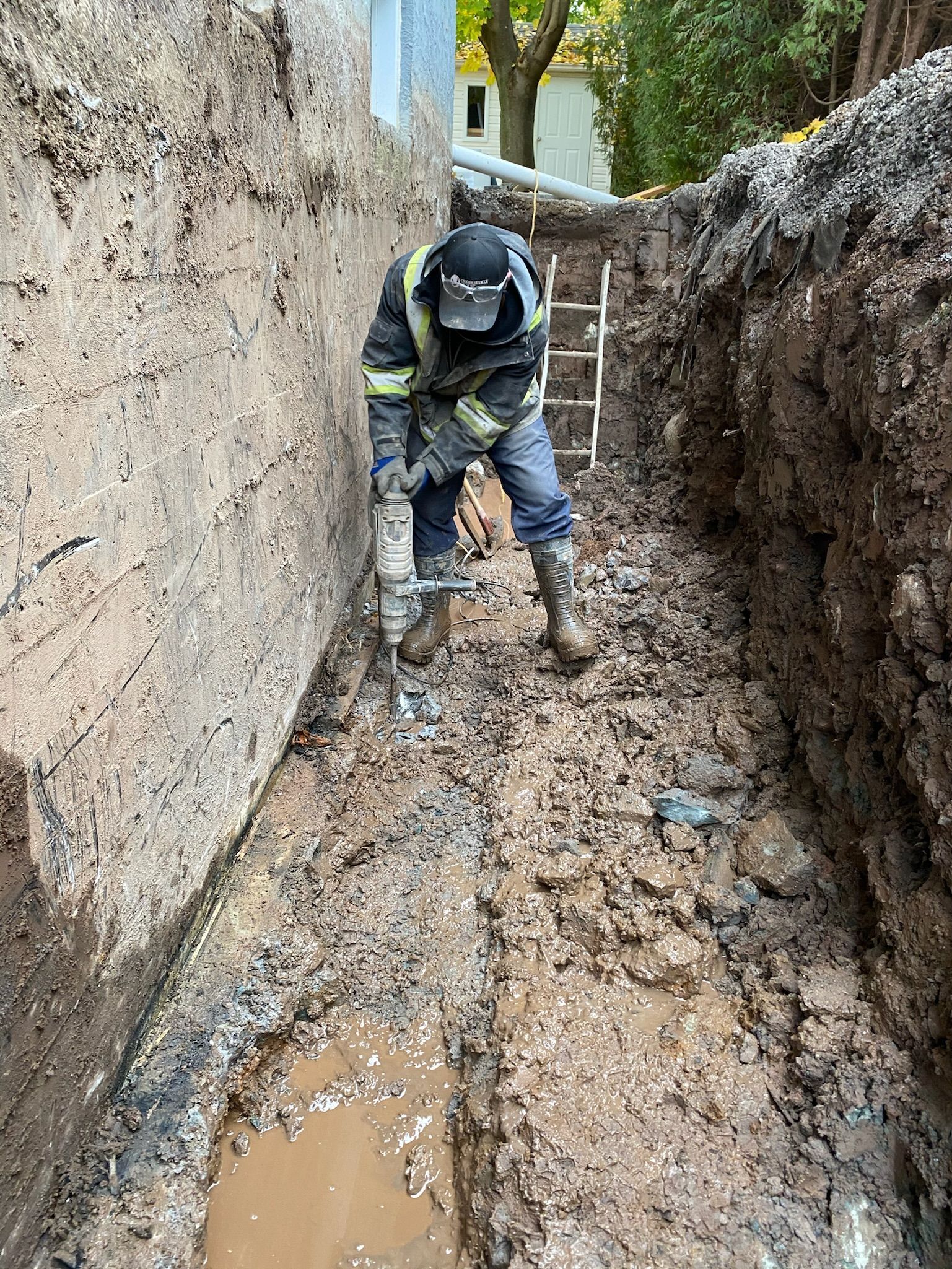 Un homme creuse un trou dans la boue.