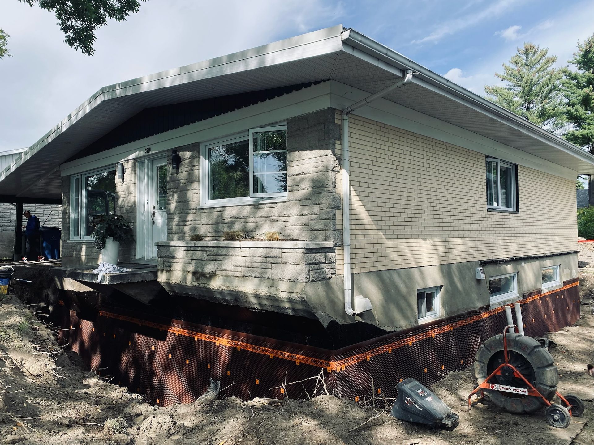Une maison avec une brouette devant elle est en train d'être déplacée.