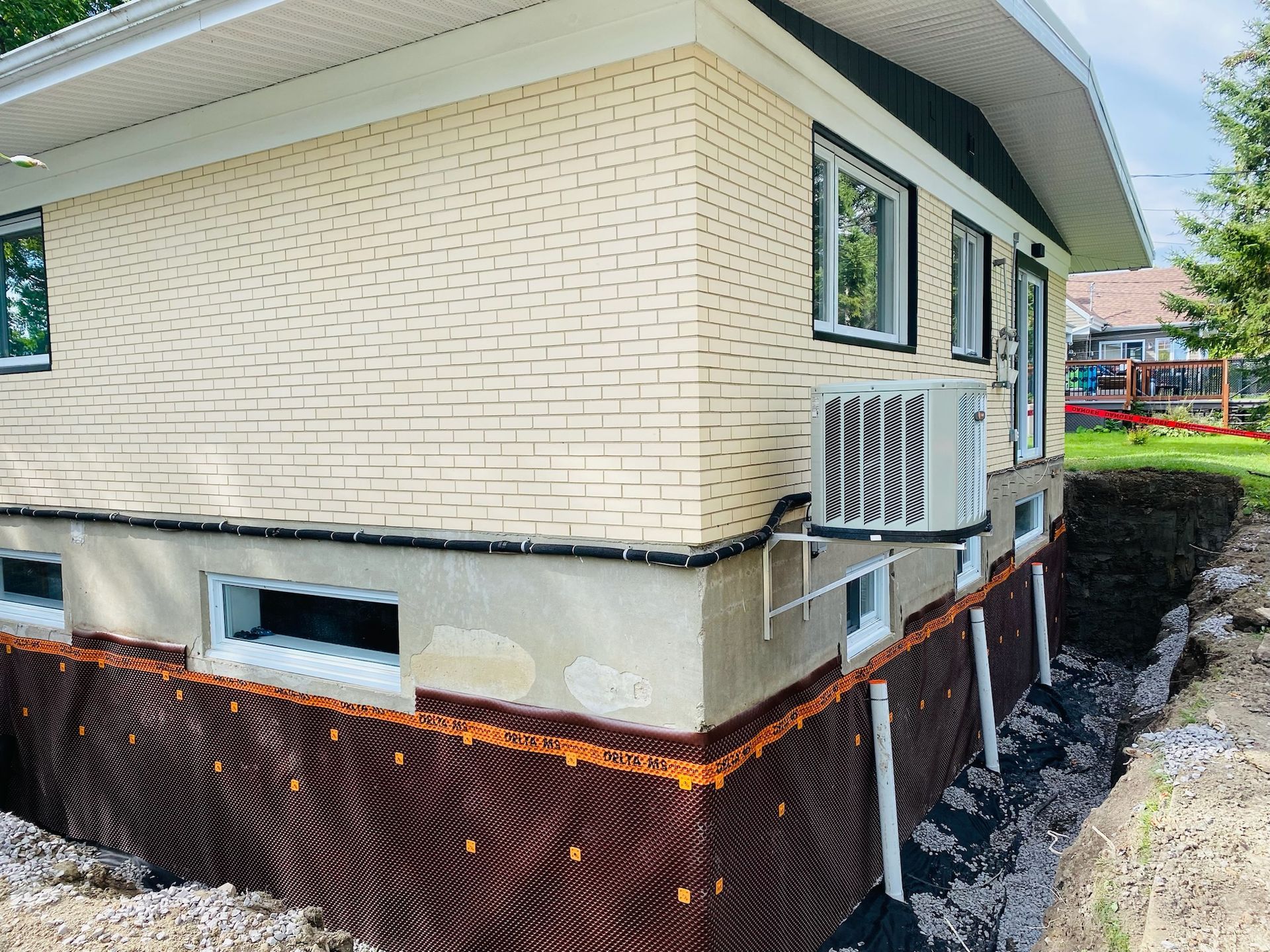 Une maison en brique avec un système de drainage sur le côté.