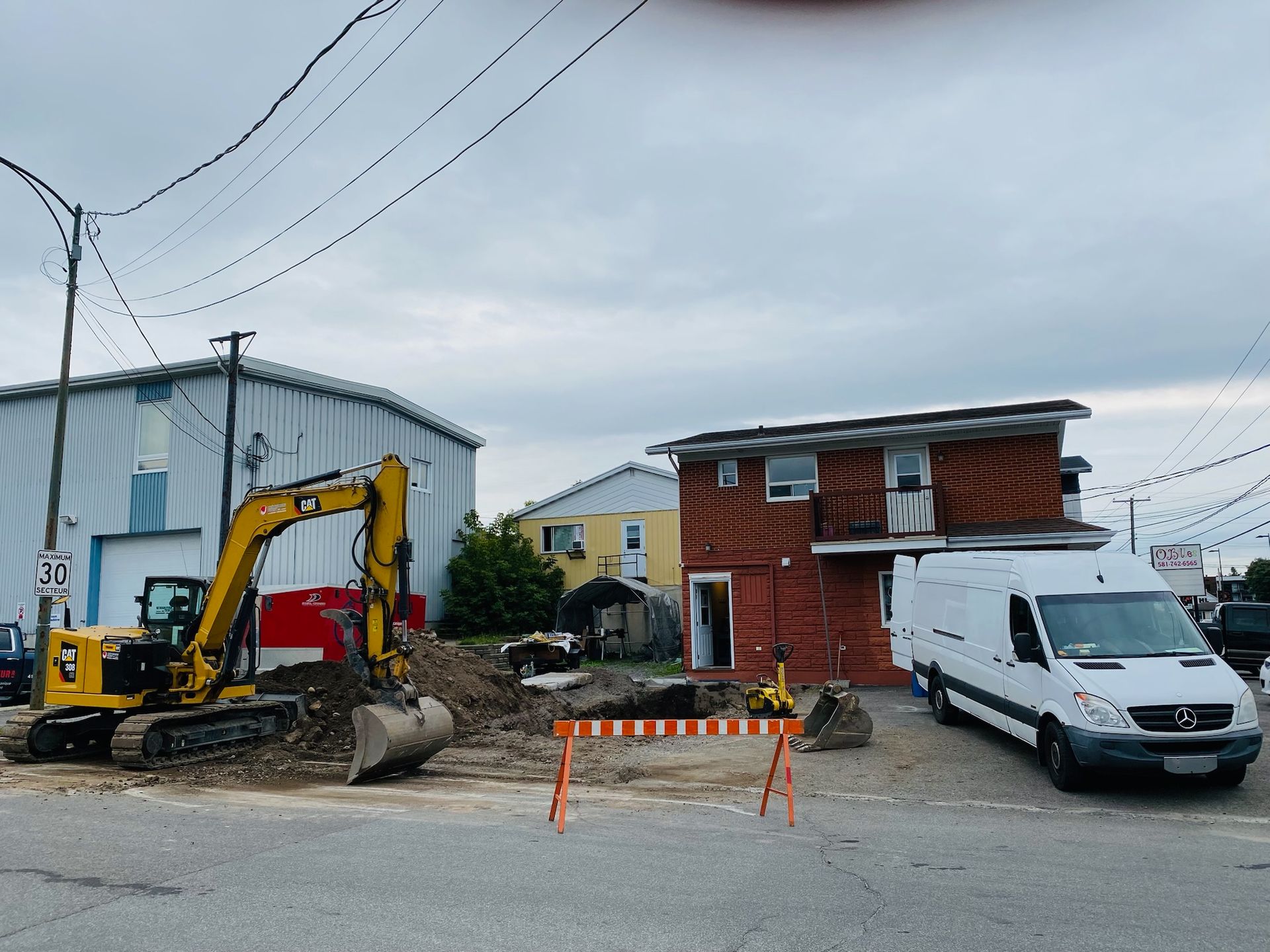 Une camionnette blanche est garée devant un chantier de construction