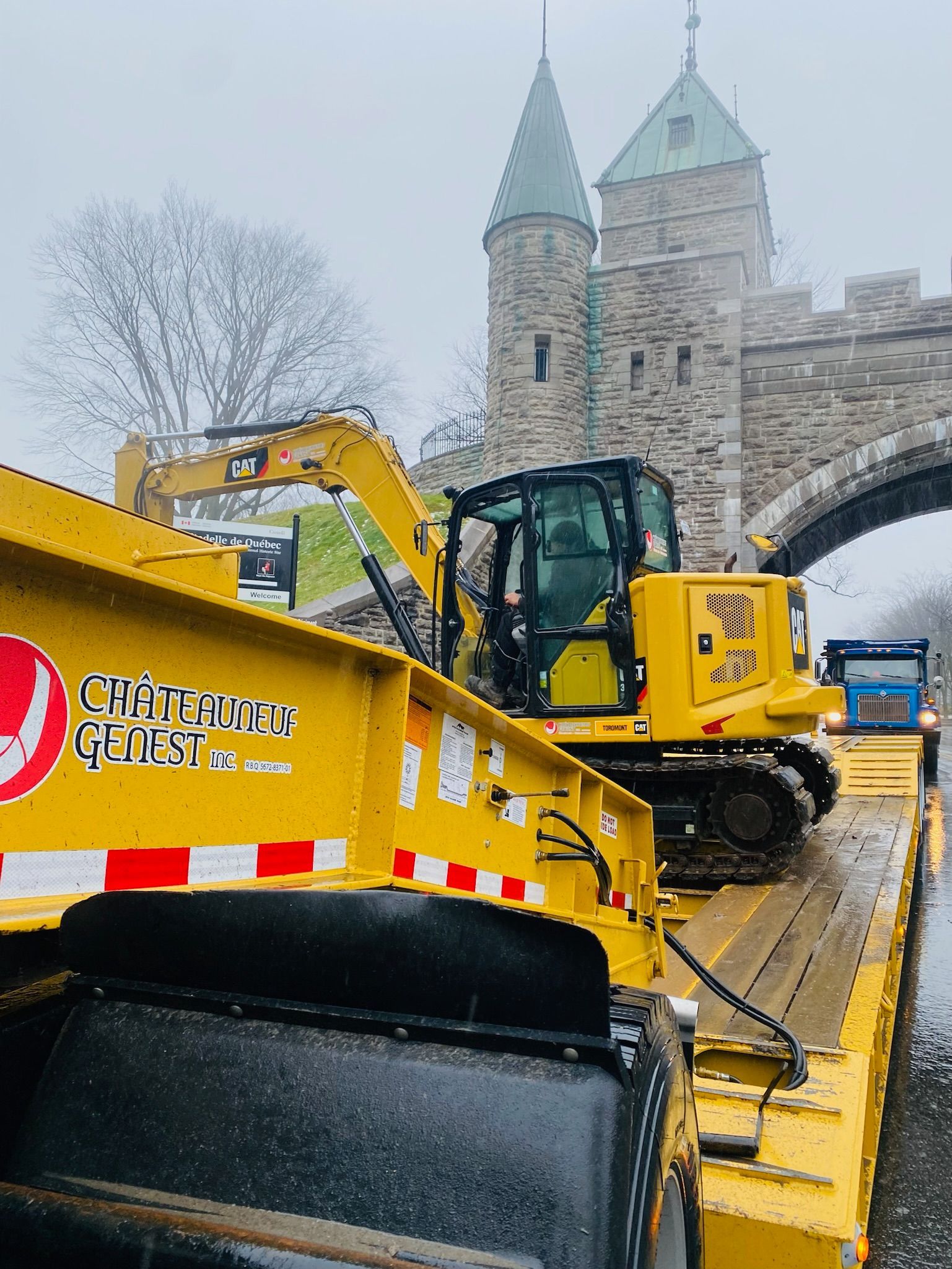Un camion jaune avec un bulldozer à l'arrière.