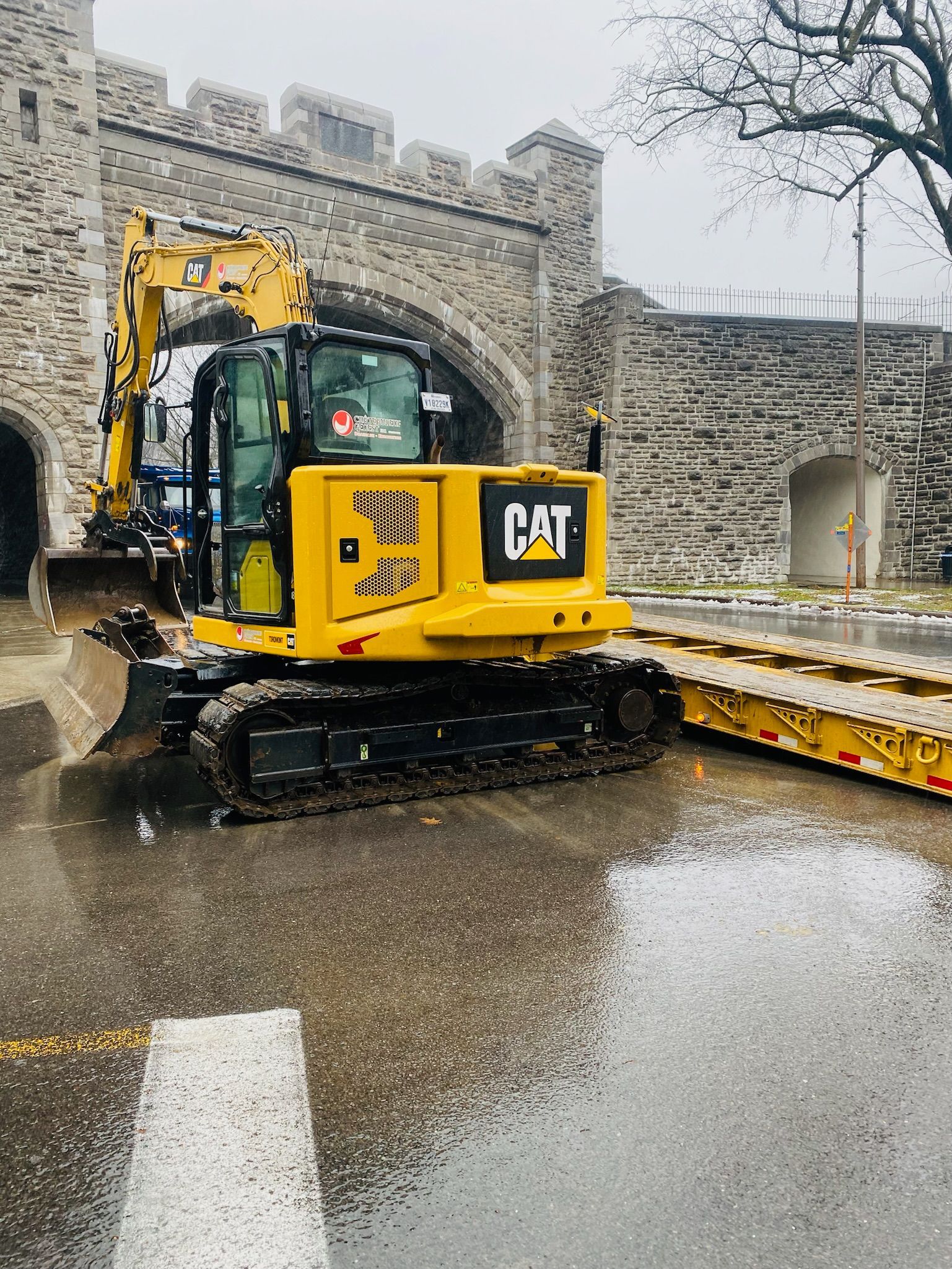 Une excavatrice jaune descend une rue inondée.