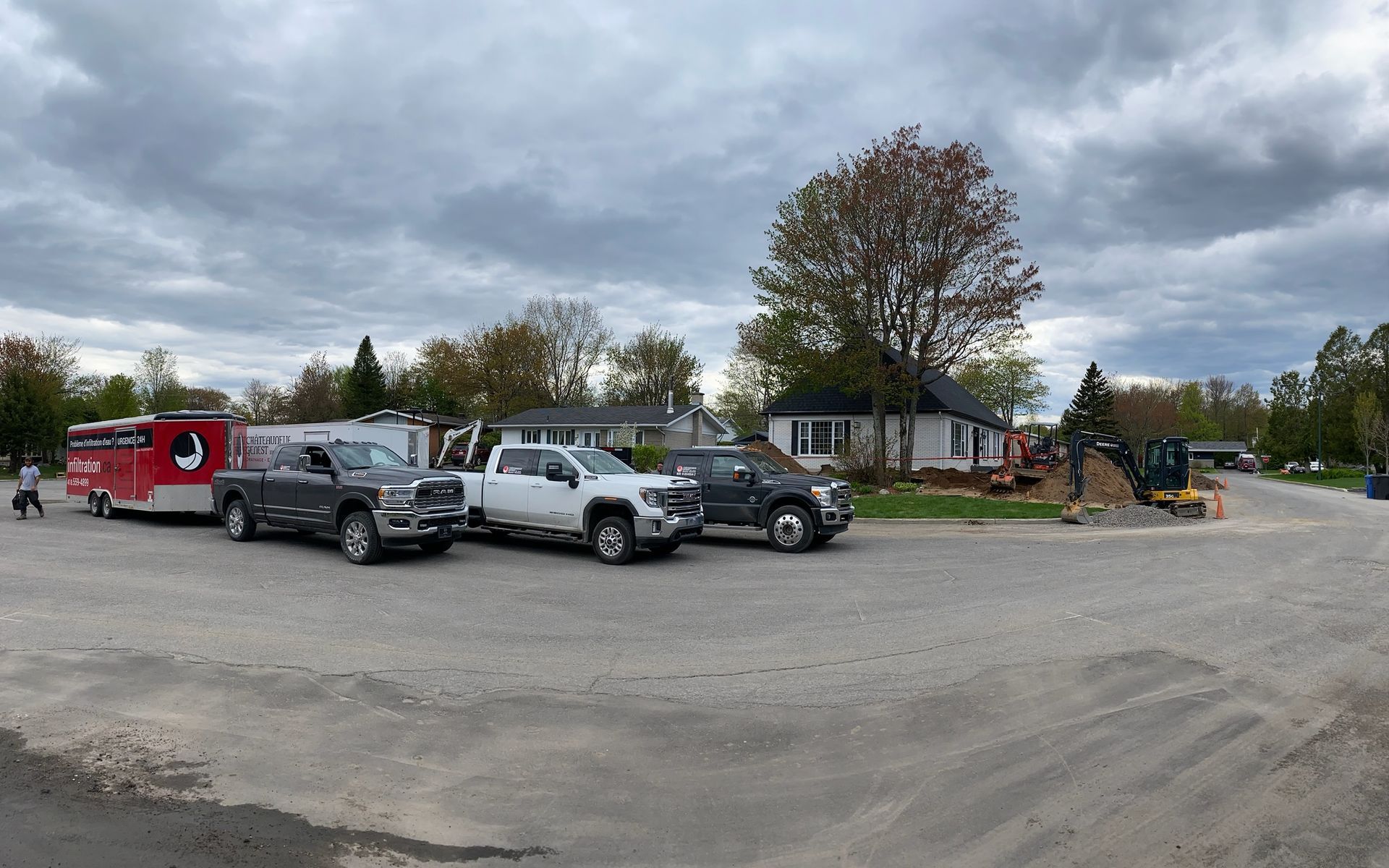 Un groupe de camions est garé sur un parking devant une maison.