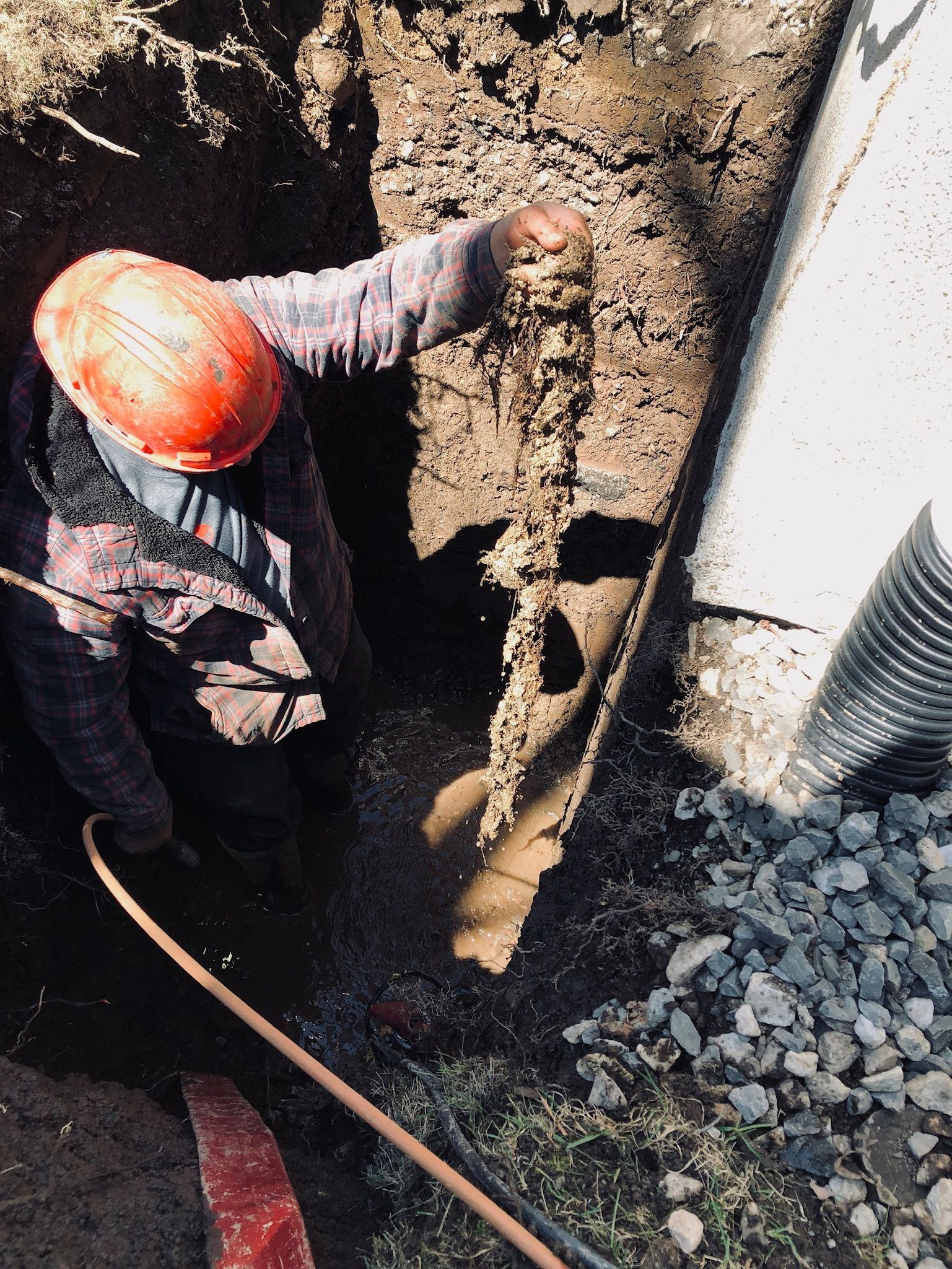Une excavatrice jaune creuse un trou dans le sol.