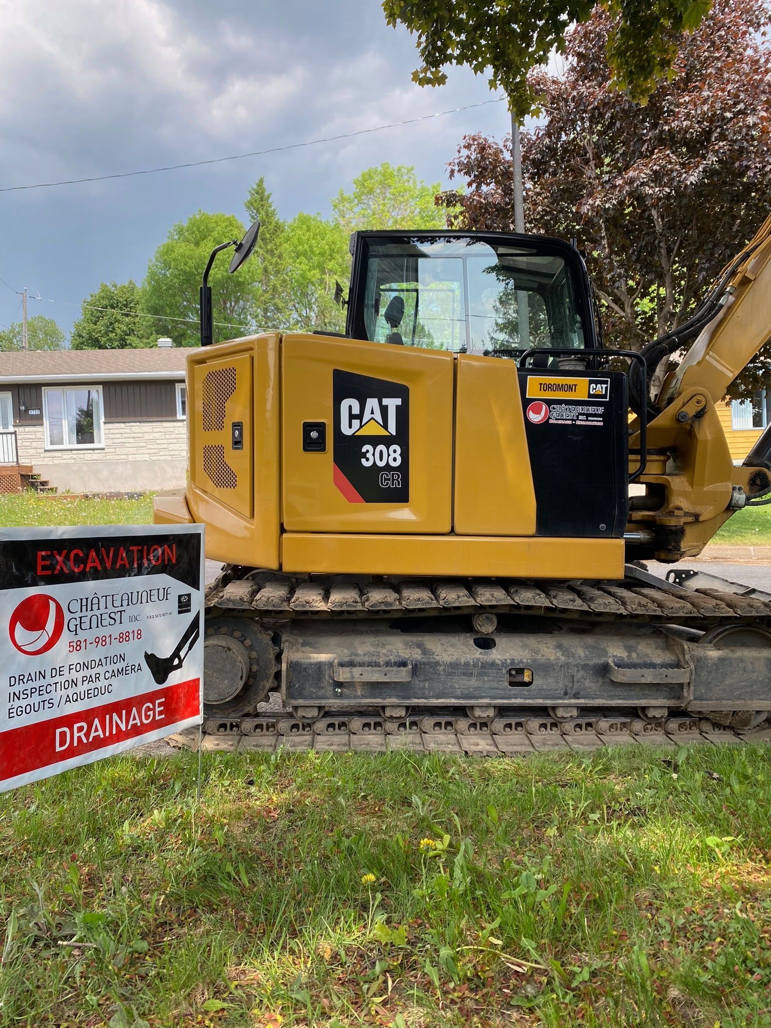 Une excavatrice à chat est garée à côté d'un panneau indiquant excavation.