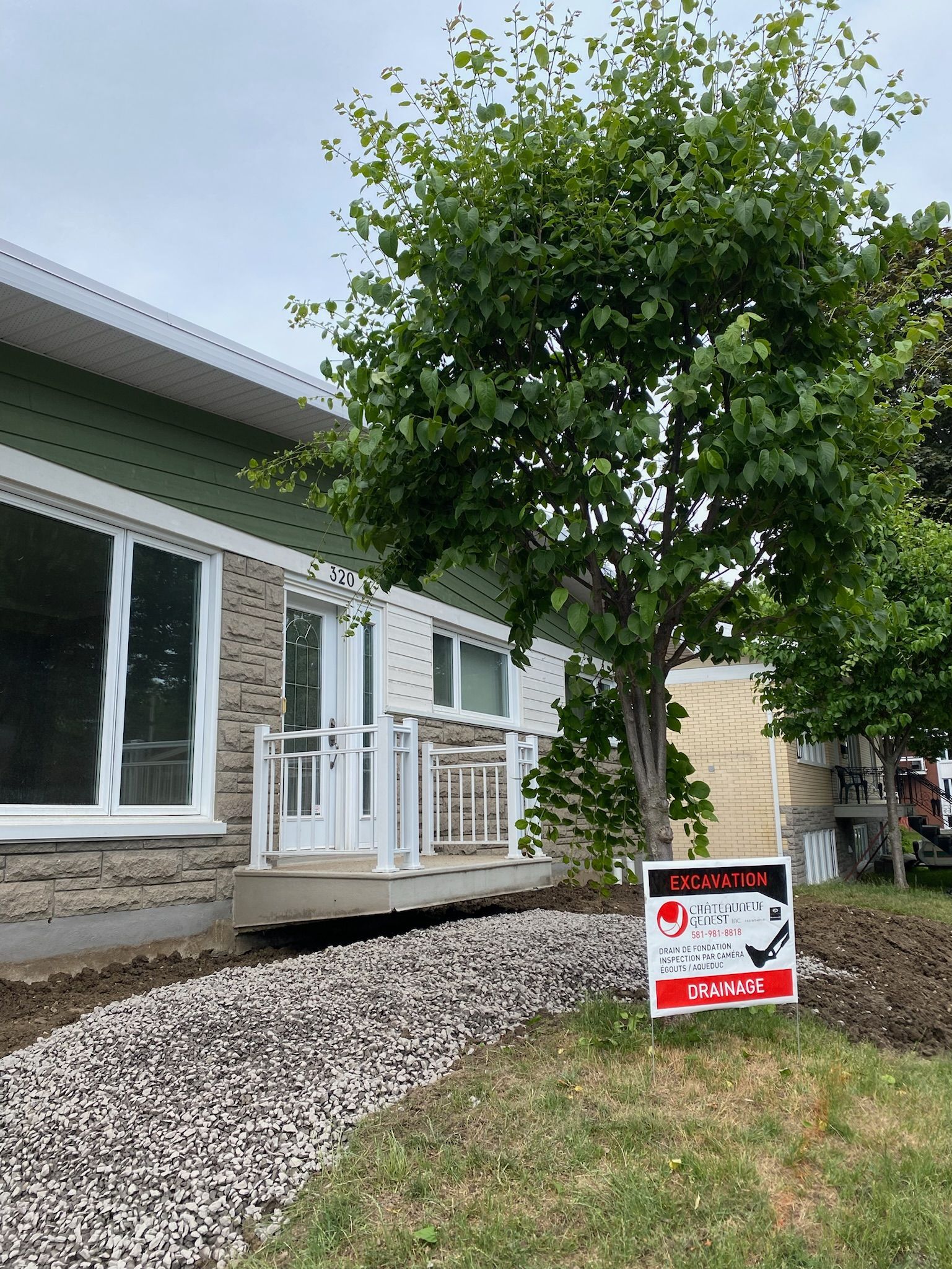 Une maison avec un panneau à vendre devant.