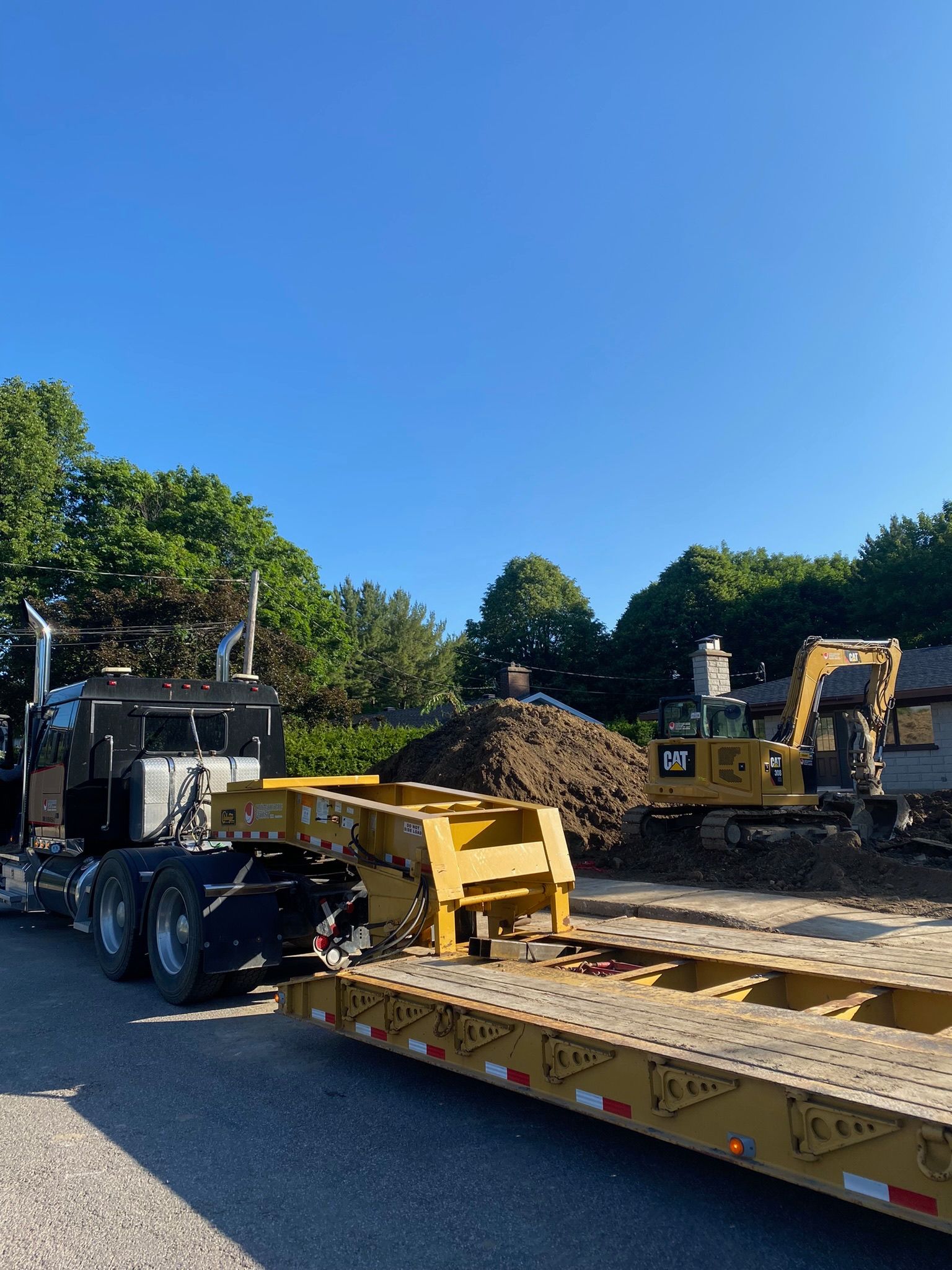 Un semi-remorque avec une remorque attachée est garé devant un chantier de construction.