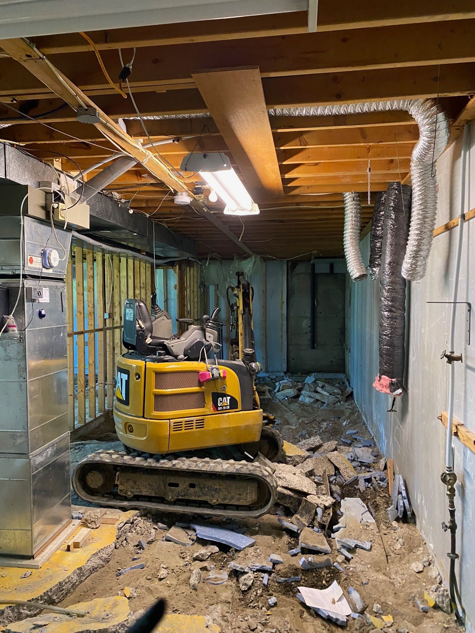 Une excavatrice jaune est assise dans un sous-sol en construction.