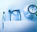 Stetoscopio, occhiali e penna in una tasca bianca, articoli medici.