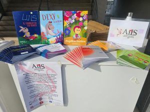 Libri e opuscoli su un tavolo. È visibile un cartello con la scritta 