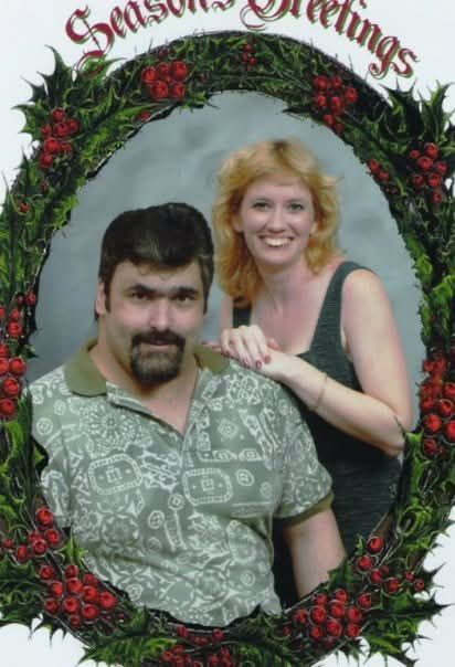 A man and a woman are posing for a picture on a christmas card