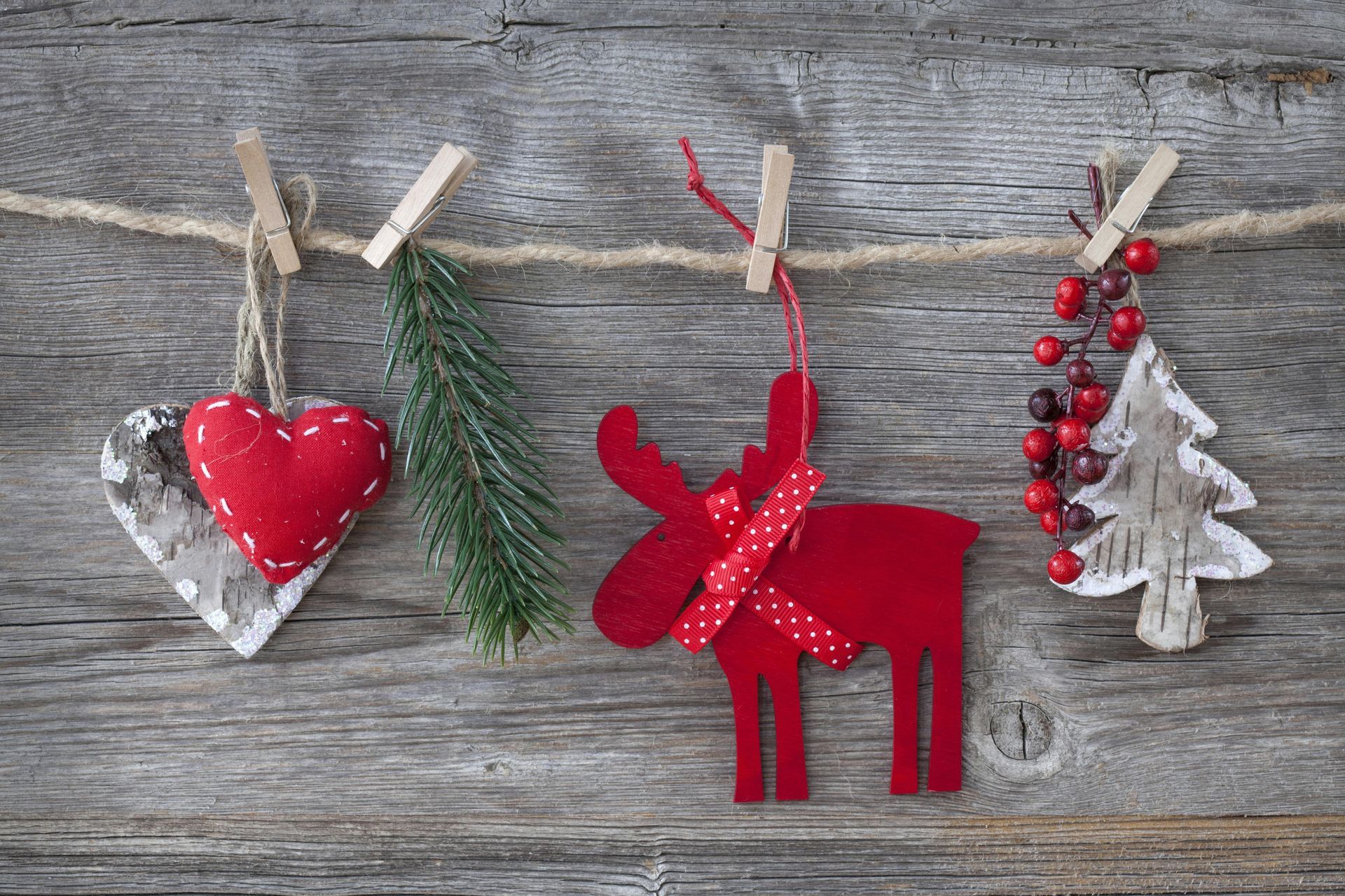Christmas decorations hanging on a clothesline on a wooden background.